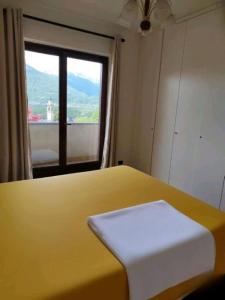 a room with a yellow bed with a window at La VILLETTA in Masera