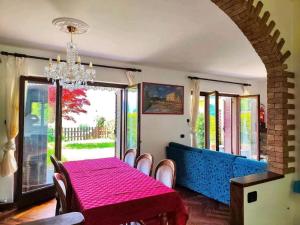 a dining room with a table and a blue couch at La VILLETTA in Masera