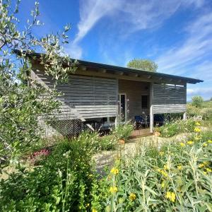 a small house with a garden in front of it at Peaceful Eco House in the Tuscan Hills in Casole dʼElsa