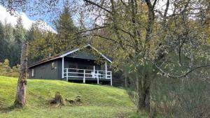 a house on a hill in a field with trees at Portnellan in Crianlarich