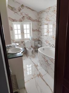 a bathroom with two sinks and a tub and a toilet at The Dragonfly Retreat in Málaga