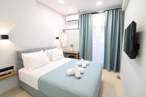 a bedroom with a bed with two towels at G&E Kavala Apartments in Kavala