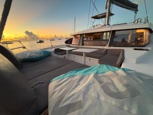 una barca con divani e tavolo sul ponte di CATAMARAN ZEPHYR EXPERIENCE EXCLUSIVE Navigation, diner, nuit, petit-déjeuner inclus a Anse des Flamands Altre 10 foto