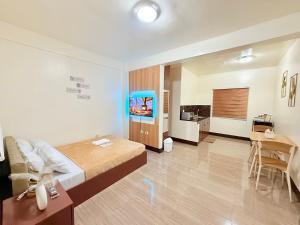 a bedroom with a bed and a desk and a kitchen at JL Suites Calbayog in Calbayog