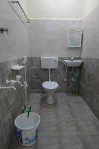 a bathroom with a toilet and a sink at Sivan Paadham Nilayam Guest House in Tiruvannāmalai