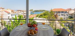 a table with a bowl of fruit and drinks on a balcony at Amara Sea View - Luxury Living Lefkada in Nydri