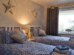 two beds in a bedroom with stars on the wall at Driftwood in Godshill
