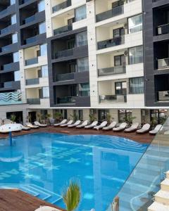 a large swimming pool with lounge chairs and a building at Hotel Building Stefan Resort I Nord in Mamaia Nord