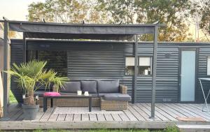 a couch sitting on a deck with a pergola at De Polderhoeve in Heerhugowaard +14 photos