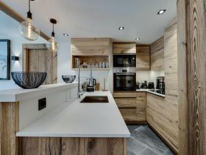 a kitchen with wooden cabinets and a white counter top at Appartement 95m², Sud-Est, Jacuzzi, Val d'Isère, 4 Suites, Parking, Animaux OK - FR-1-567-73 in Val dʼIsère