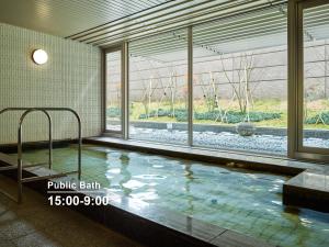 a swimming pool in a building with a large window at Mitsui Garden Hotel Kyoto Shijo in Kyoto