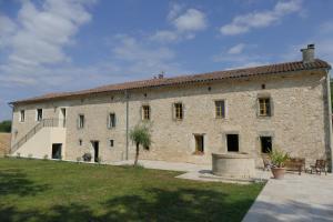 un grande edificio in pietra con un prato davanti di Domaine D'Issac a Vénès
