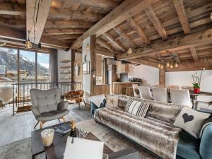 a living room with a couch and a table at Appartement Duplex avec Terrasse, Jacuzzi et Cheminée - Val-d'Isère - FR-1-567-63 in Val dʼIsère