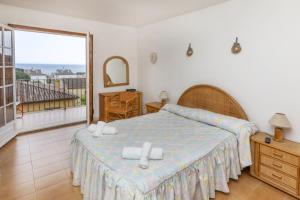 una camera da letto con un letto e una grande finestra di La Paloma a Palafrugell