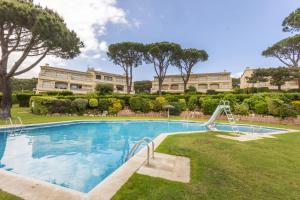 una piscina con scivolo di fronte a un edificio di La Paloma a Palafrugell