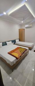 a bedroom with two beds in a room at Hotel Avanue Villa in Dabhoi