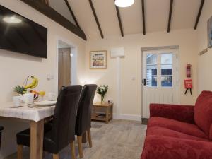 ein Wohnzimmer mit einem Tisch und einer roten Couch in der Unterkunft Kingfisher Cottage in Wainfleet All Saints