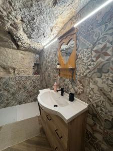 a bathroom with a sink and a mirror at La grotta Mutycense in Modica