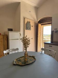 a table in a kitchen with a vase on it at La grotta Mutycense in Modica