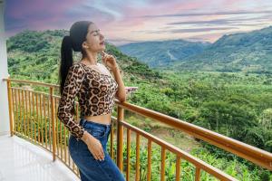 Una mujer parada en un balcón con vistas a las montañas en Recreo Hotel Aldea, en San Antonio