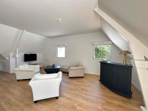 a living room with white furniture and a staircase at Écrin Neuf au Cœur du Golf in Saint-André-des-Eaux