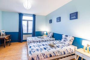 una camera da letto con pareti blu, un letto e una scrivania di Villa Au Beau Site Jardin, Cheminée & Mer proche a Merlimont