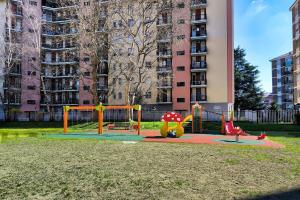 un parque infantil frente a un edificio alto en Apartament Perła, en Milán