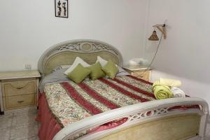 a bedroom with a large bed with green pillows at Dar Al Hajja Fatima in Rabat