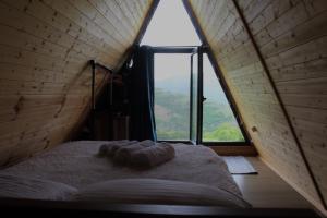 a bed in a room with a large window at ''Sunflower'' in Dushetʼi