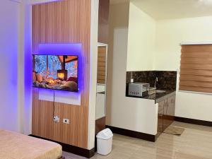 a room with a tv on a wall with a bed at JL Suites Calbayog in Calbayog