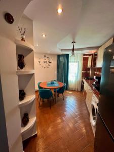 a kitchen and dining room with a table and chairs at ND Apartament in Râmnicu Vâlcea