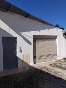 a white building with two garage doors on it at Loc'Issime ! Clim - PK privé gratuit in Le Gond