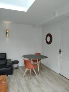 a room with a table and chairs and a clock on the wall at Loc'Issime ! Clim - PK privé gratuit in Le Gond +10 photos