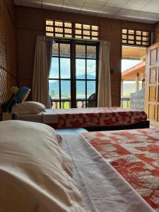 a bedroom with two beds and a large window at Monton Guest House in Rantepao