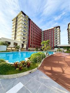 ein Schwimmbad vor einigen hohen Gebäuden in der Unterkunft Primeworld District Condoresort 15mins2airport in Mactan Island