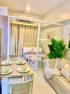 ein Zimmer mit einem Bett und einem Tisch und Stühlen in der Unterkunft Primeworld District Condoresort 15mins2airport in Mactan Island + 46 Fotos