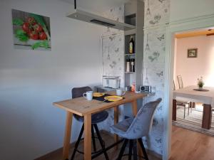 a small kitchen with a wooden table and two chairs at Ferienwohnung am Bach in Altenkunstadt +5 photos