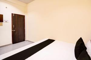 Zimmer mit einem Bett und einer Holztür in der Unterkunft HOTEL O S S STAY INN in Nagpur