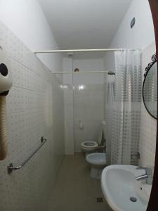 a white bathroom with a toilet and a sink at Albergo Ristorante Gualtieri in Barberino di Mugello +30 photos