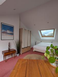 a bedroom with a bed and a table and a window at Studio idéalement situé au cœur de la ville et des activités in Loudéac