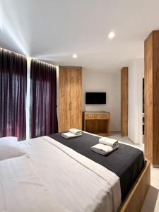 a bedroom with a large bed and a television at Kompleksi Muja in Velipojë