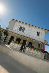 a white house with a fence in front of it at Koci Apartments in Sarandë