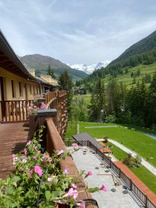 a balcony with a view of a field and mountains at Maison Poluc Boutique Hotel in Champoluc