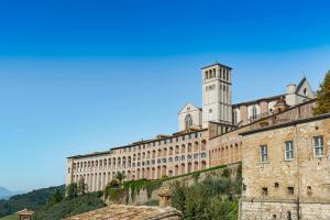 a large building with a clock tower on top of it at La Cripta - a due passi dalla Basilica - ItalyWeGo in Santa Maria degli Angeli