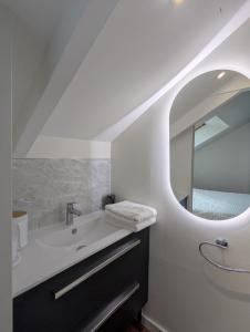 a bathroom with a sink and a mirror at Studio idéalement situé au cœur de la ville et des activités in Loudéac