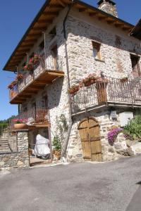 een stenen gebouw met balkons en bloemen erop bij Monte Emilius Alloggio ad uso turistico VDA SAINT CHRISTOPHE n 0002 in Saint-Christophe