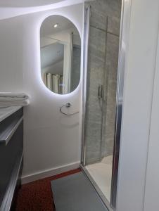 a bathroom with a shower with a glass door at Studio idéalement situé au cœur de la ville et des activités in Loudéac +1 photo