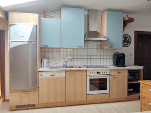a kitchen with wooden cabinets and a stainless steel refrigerator at Haus Enzian in Mittersill