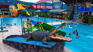 Una estatua de cocodrilo en una piscina de un parque acuático. en Recreo Hotel Aldea, en San Antonio 2 fotos más