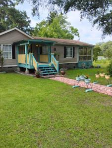 a house with a porch with chairs in the yard at Serenity Now Sunset Beach in Sunset Beach
